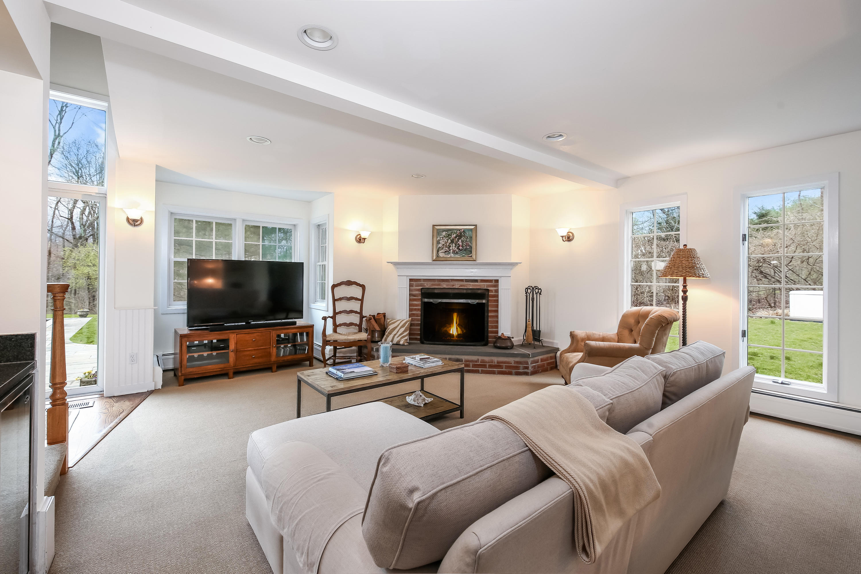 2 4 Acres Road Darien, CT 06820 - Photo 13 of 26 a living room with furniture a flat screen tv and a fireplace