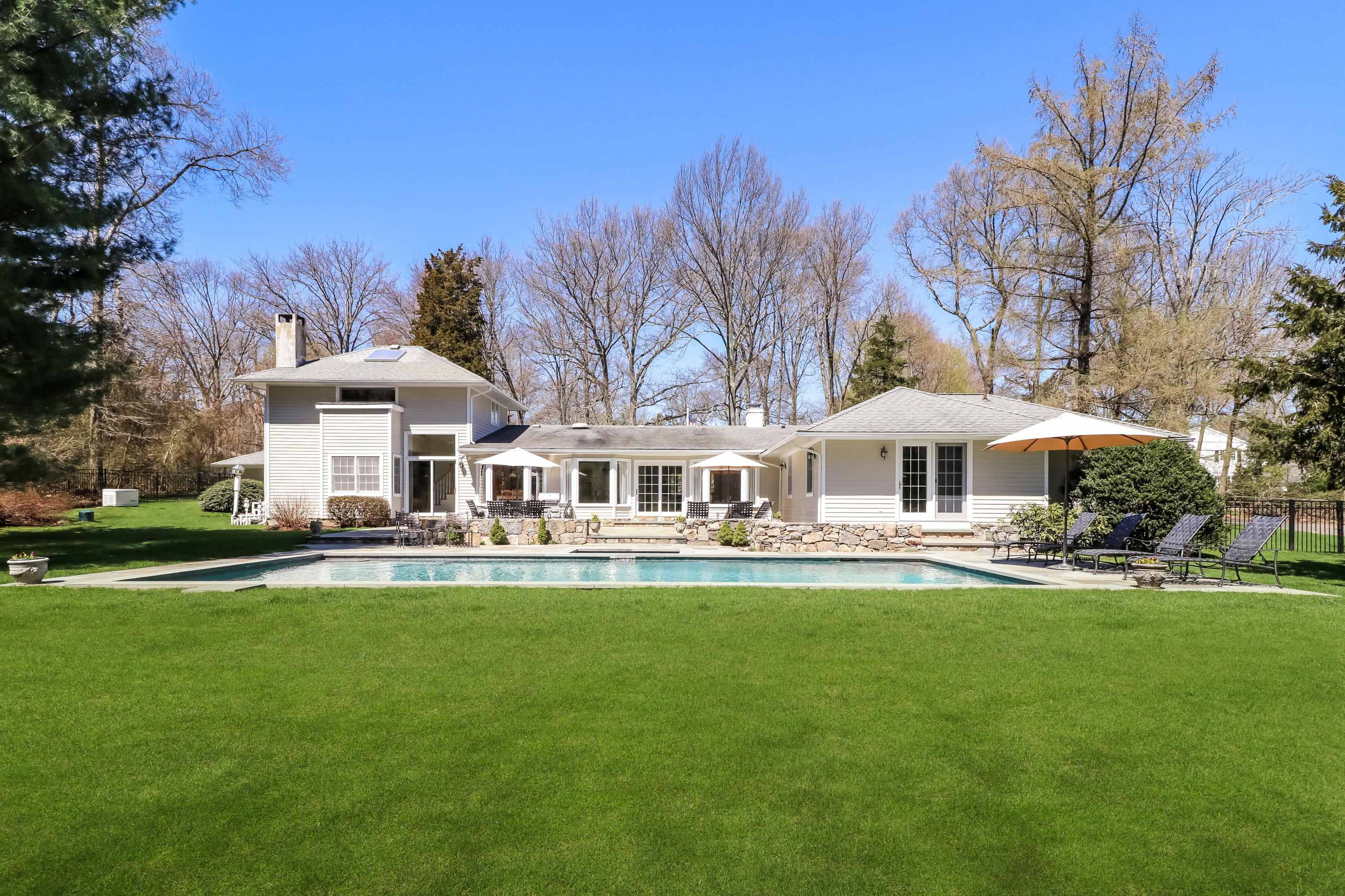 2 4 Acres Road Darien, CT 06820 - Photo 2 of 26 a front view of a house with swimming pool and green space