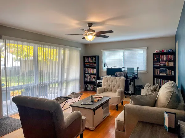 a living room with furniture a bookshelf and a large window