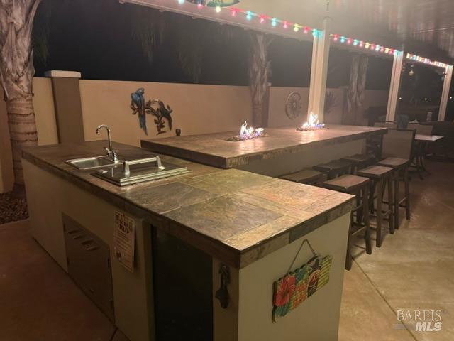 331 Frisbie Circle Vacaville, CA 95688 - Photo 80 of 99 Outside bar area lit up at night here featuring 2 built in table top fire pits, refrigerator, sink and wonderful patio lighting too!
