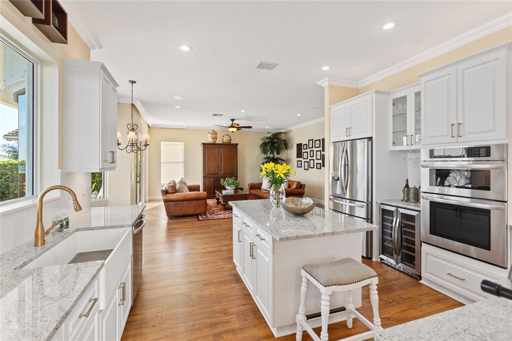 19239 Southwest 54th Street Miramar, FL 33029 - Photo 21 of 82 a large kitchen with stainless steel appliances granite countertop a stove a sink dishwasher a refrigerator and a dining table with wooden floor