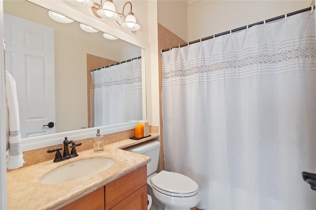 19239 Southwest 54th Street Miramar, FL 33029 - Photo 34 of 82 a bathroom with a sink a toilet a mirror and shower curtain
