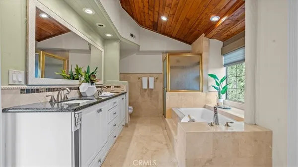 a spacious bathroom with a granite countertop sink a mirror and a shower