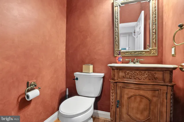 a bathroom with a toilet a sink and mirror