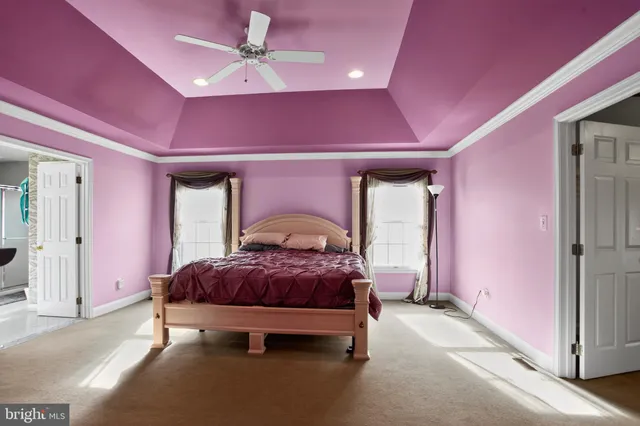a spacious bedroom with a bed and a chandelier