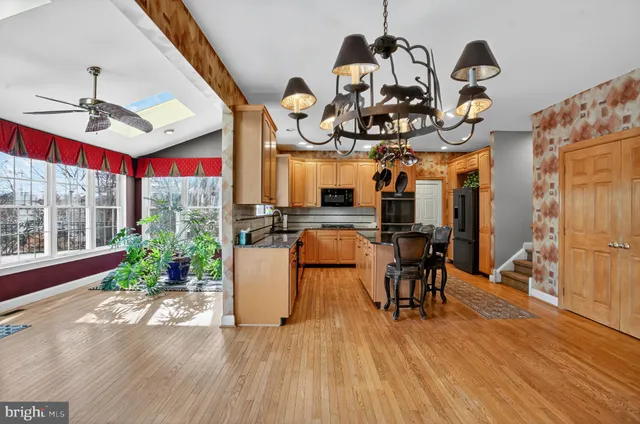 a view of a dining room with furniture a chandelier and wooden floor