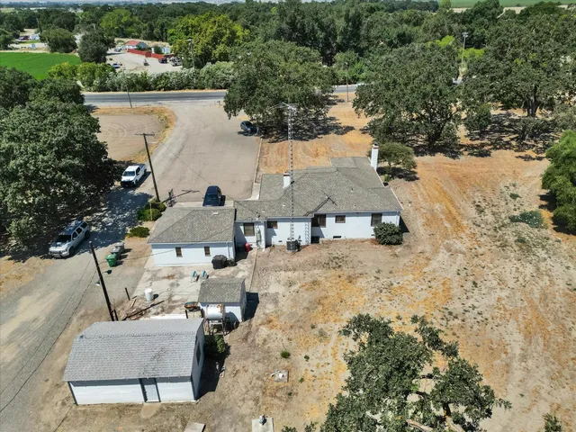 a kitchen with stainless steel appliances granite countertop a refrigerator a sink dishwasher a stove and a dining table with wooden cabinet