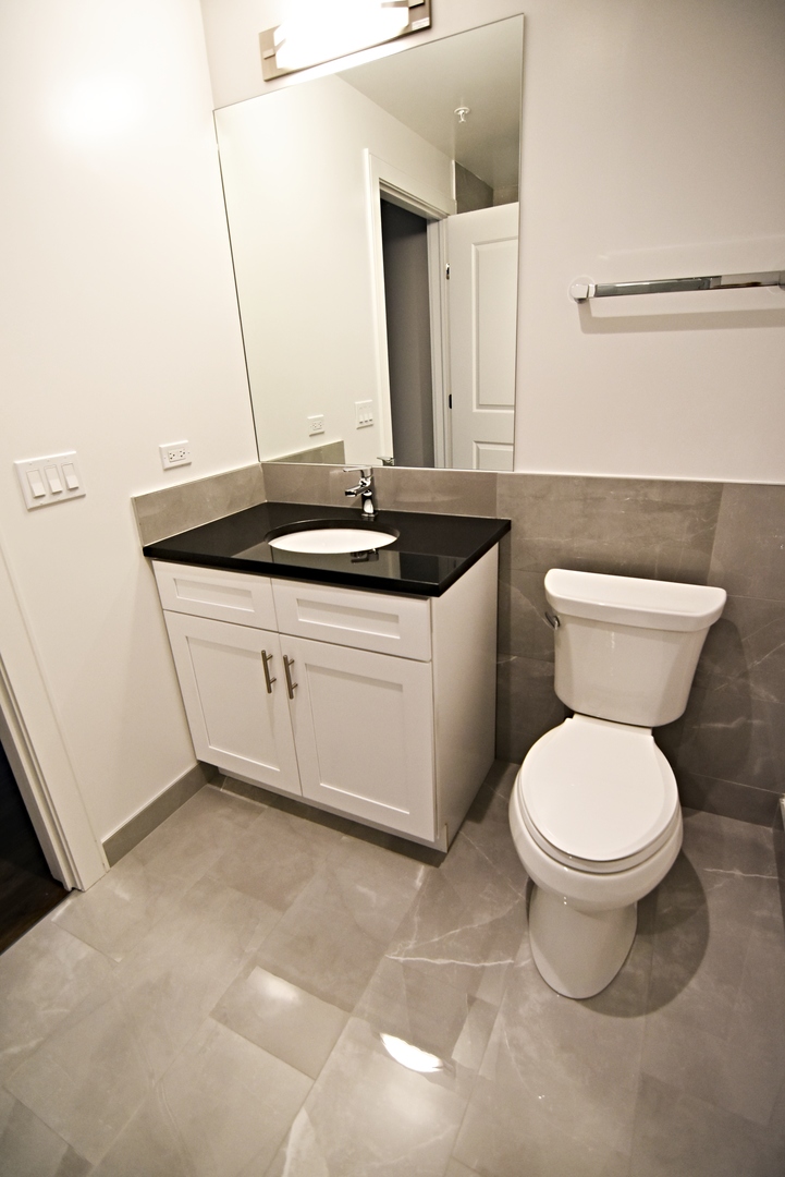 3833 North Broadway, Unit 720 Chicago, IL 60613 - Photo 11 of 11 a bathroom with a toilet sink and mirror