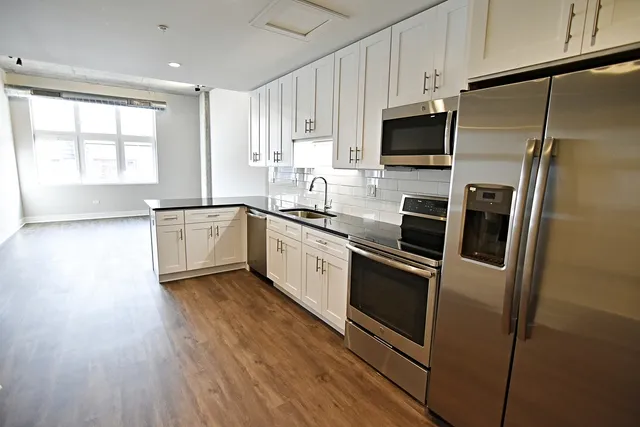 a kitchen with stainless steel appliances a refrigerator sink and microwave