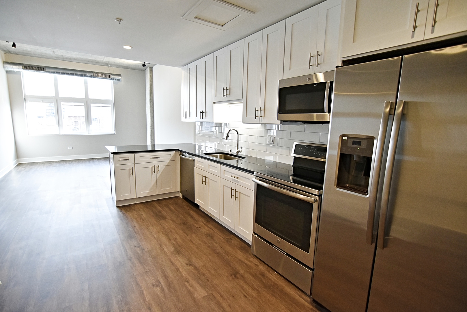 3833 North Broadway, Unit 720 Chicago, IL 60613 - Photo 5 of 11 a kitchen with stainless steel appliances a refrigerator sink and microwave