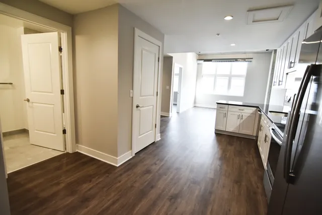 a view of a big room with wooden floor and windows