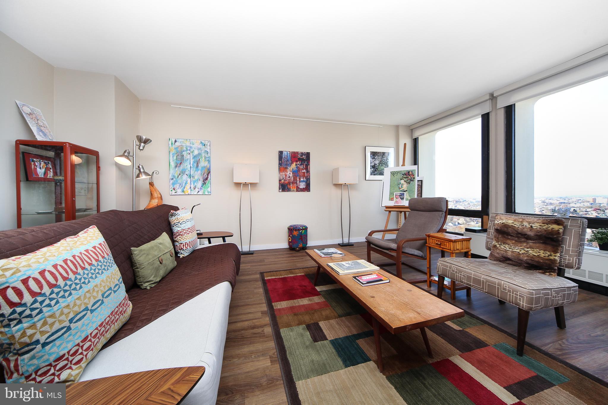 210 Locust Street, Unit 21E Philadelphia, PA 19106 - Photo 13 of 51 a living room with furniture and a floor to ceiling window