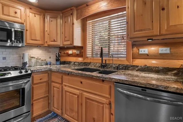 a kitchen with granite countertop a sink and a stove