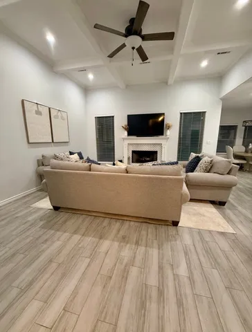 a large room with a large center island wooden floor stainless steel appliances and cabinets