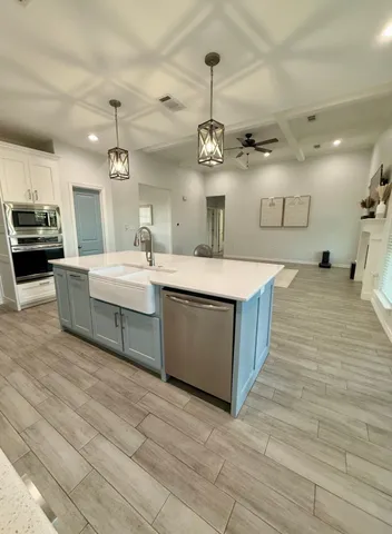 a kitchen with stainless steel appliances a stove a microwave and a table