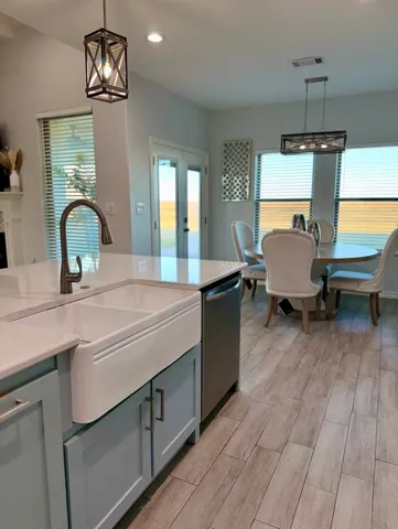 a kitchen with stainless steel appliances granite countertop a sink a stove and a wooden floors