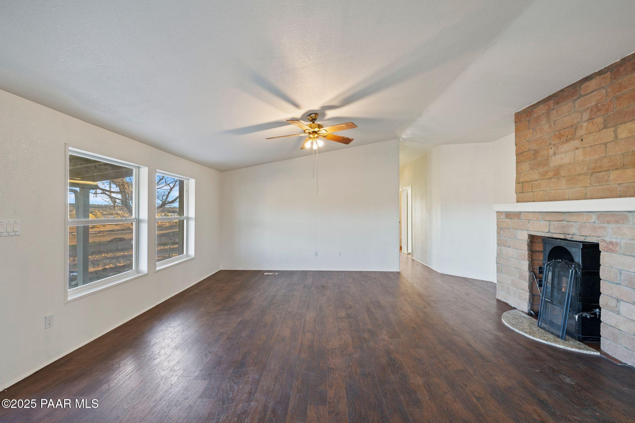 24580 North St Louis Street Paulden, AZ 86334 - Photo 4 of 26 a view of an empty room with wooden floor and a fireplace