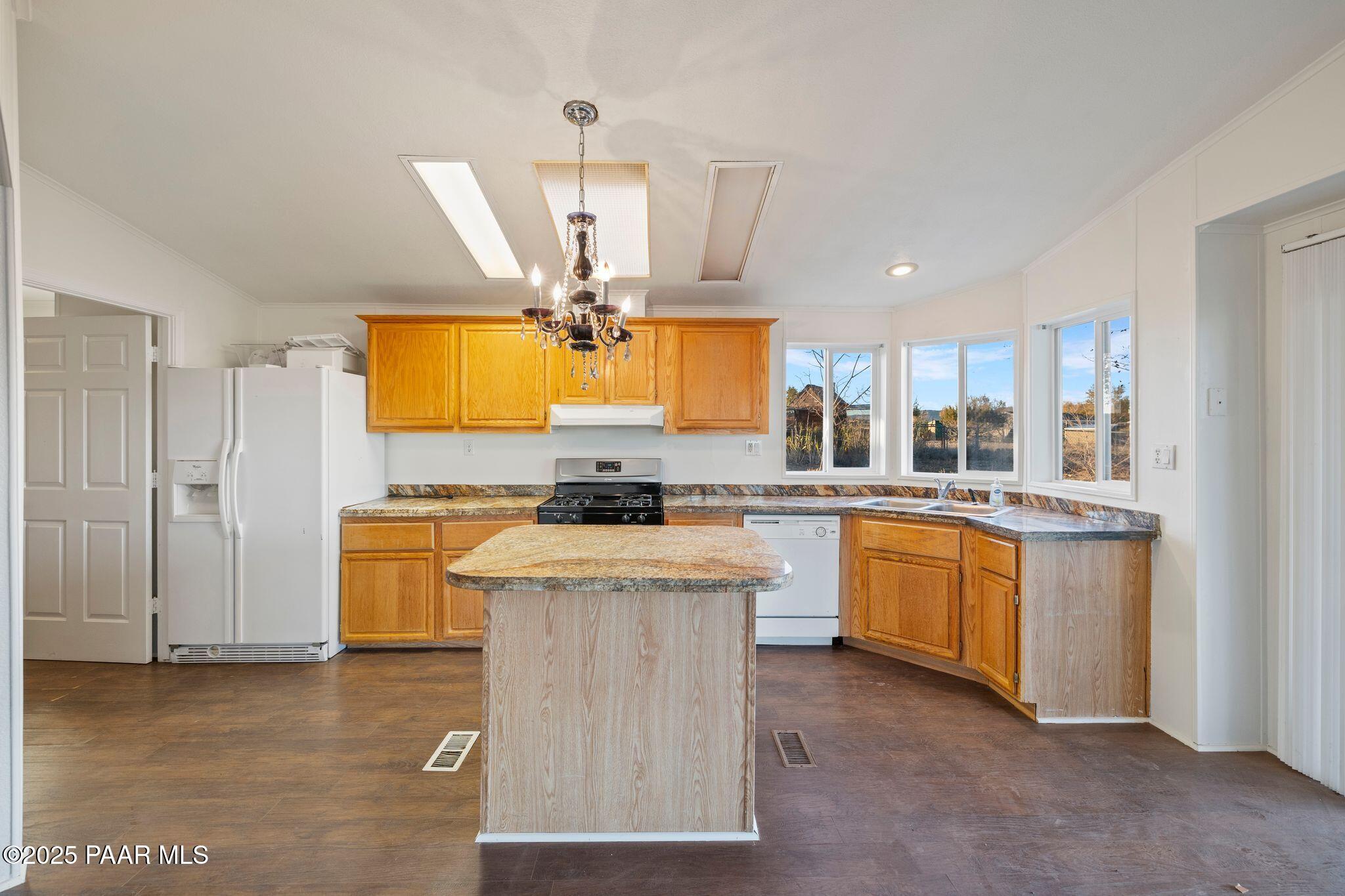24580 North St Louis Street Paulden, AZ 86334 - Photo 8 of 26 a kitchen with stainless steel appliances granite countertop a sink a stove and a refrigerator