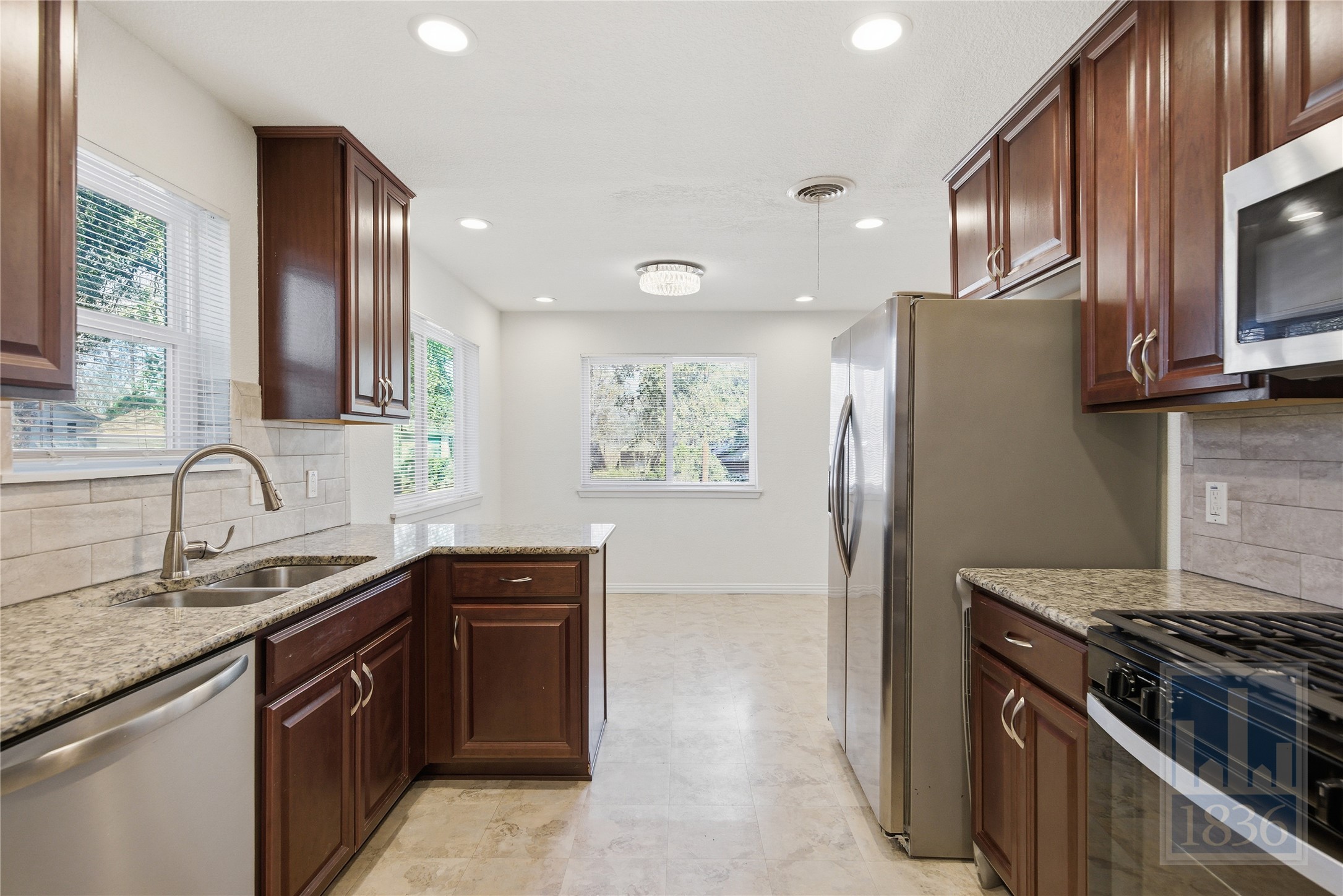 4405 Terrilance Drive Austin, TX 78741 - Photo 14 of 36 a kitchen with stainless steel appliances granite countertop a stove a sink and a refrigerator