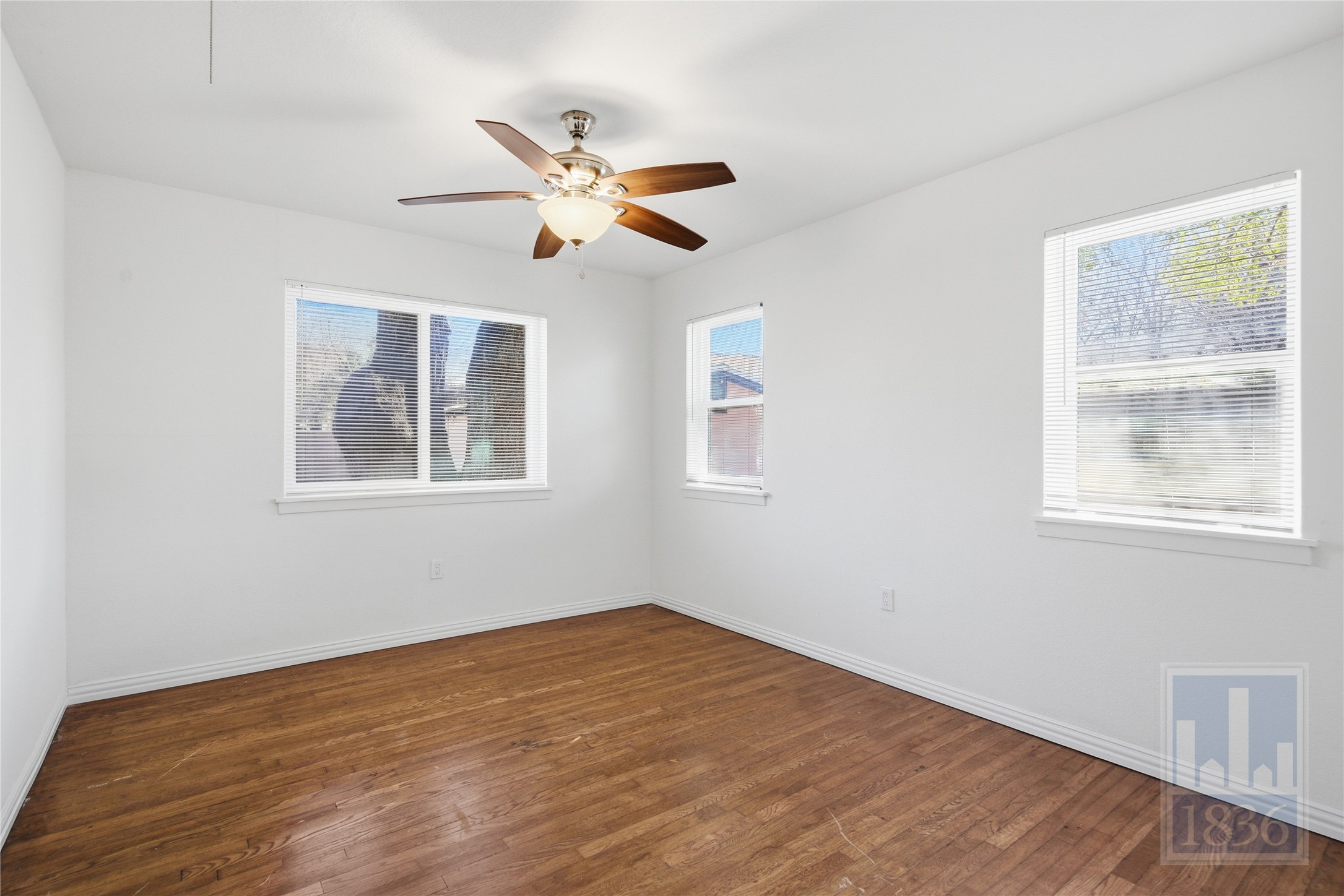 4405 Terrilance Drive Austin, TX 78741 - Photo 21 of 36 a view of empty room with wooden floor and fan