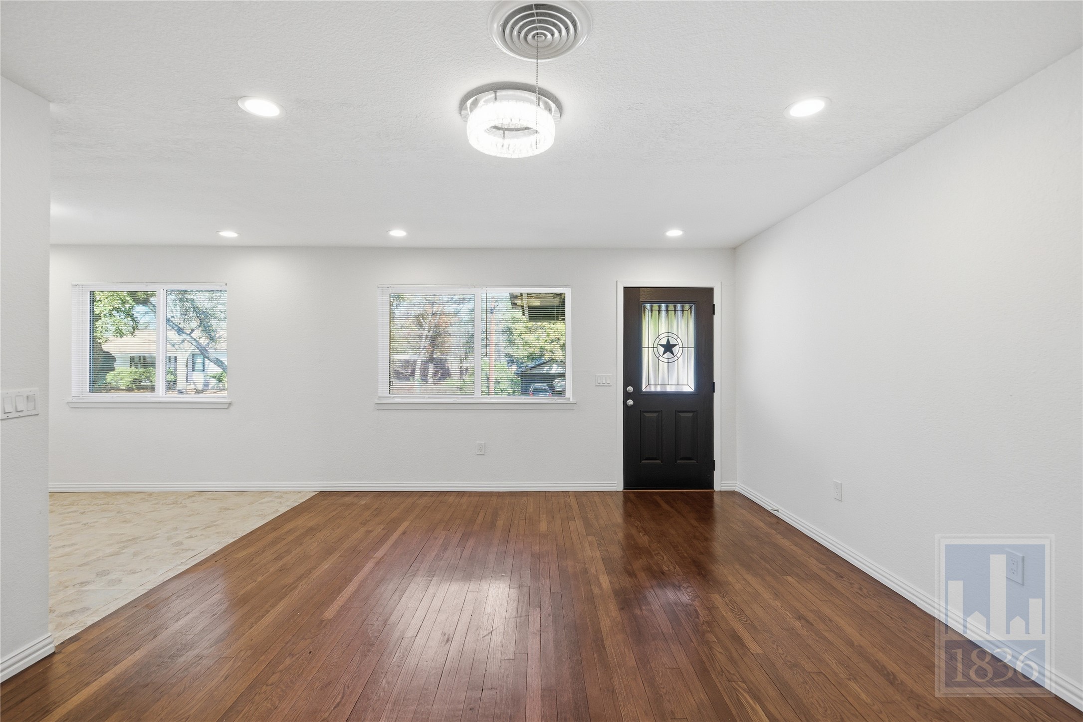 4405 Terrilance Drive Austin, TX 78741 - Photo 5 of 36 an empty room with wooden floor and windows