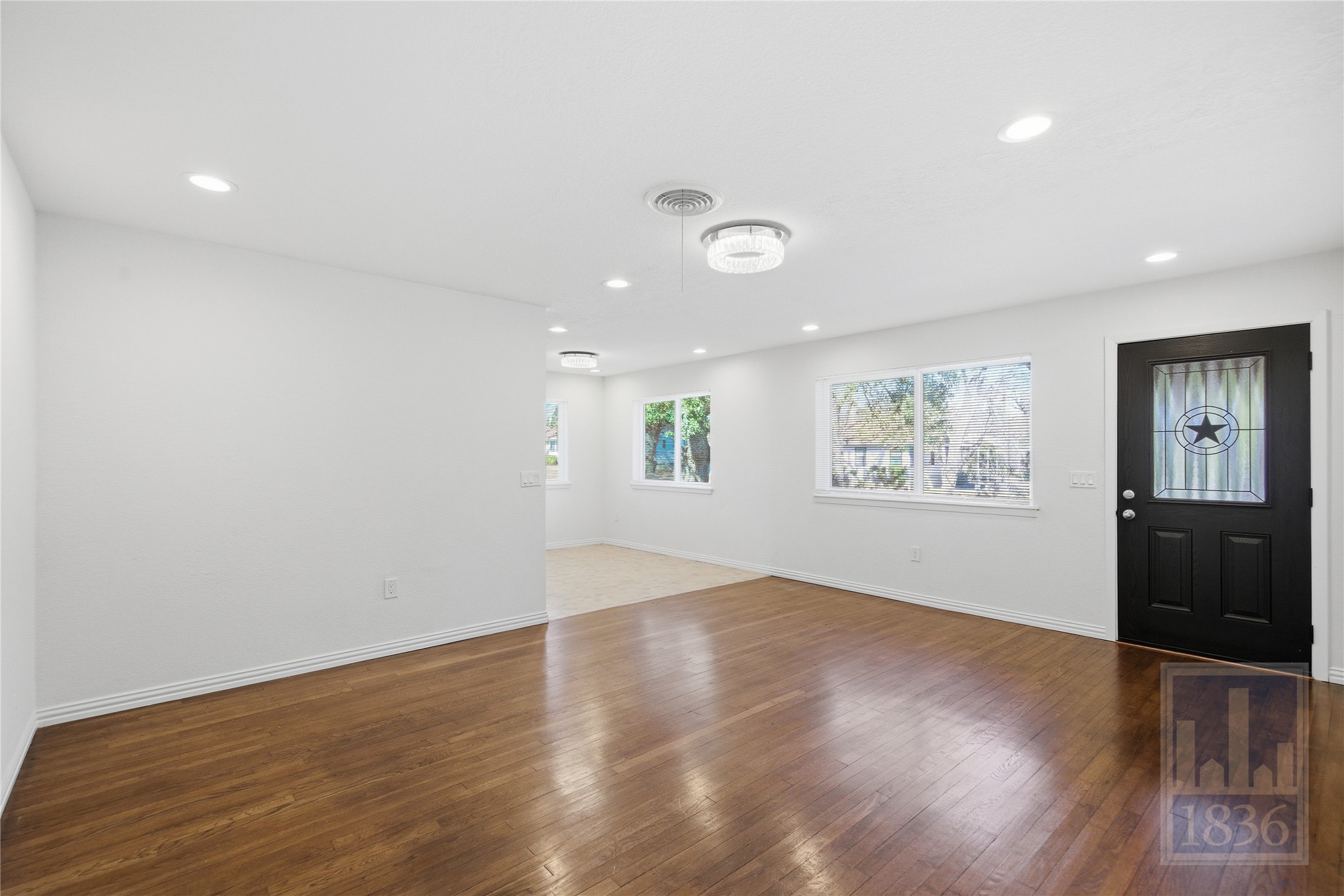 4405 Terrilance Drive Austin, TX 78741 - Photo 6 of 36 an empty room with wooden floor and windows
