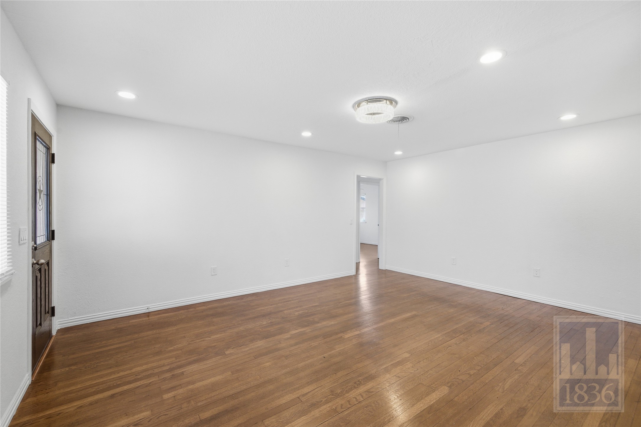 4405 Terrilance Drive Austin, TX 78741 - Photo 7 of 36 an empty room with wooden floor and windows