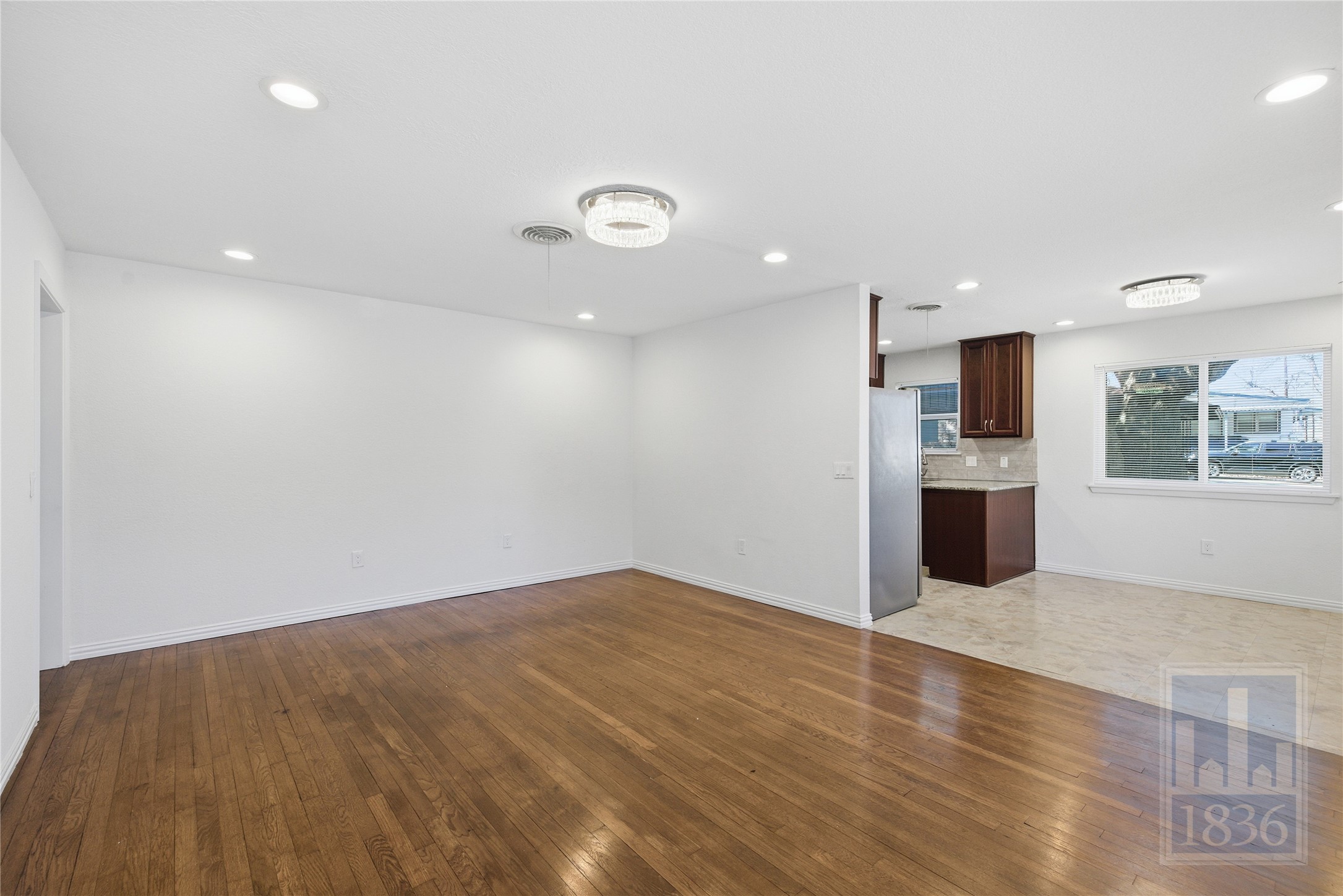 4405 Terrilance Drive Austin, TX 78741 - Photo 8 of 36 an empty room with a kitchen and natural light