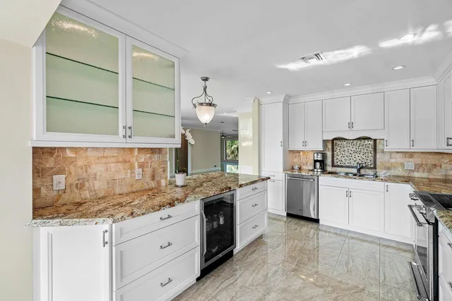 a kitchen with granite countertop white cabinets and white appliances