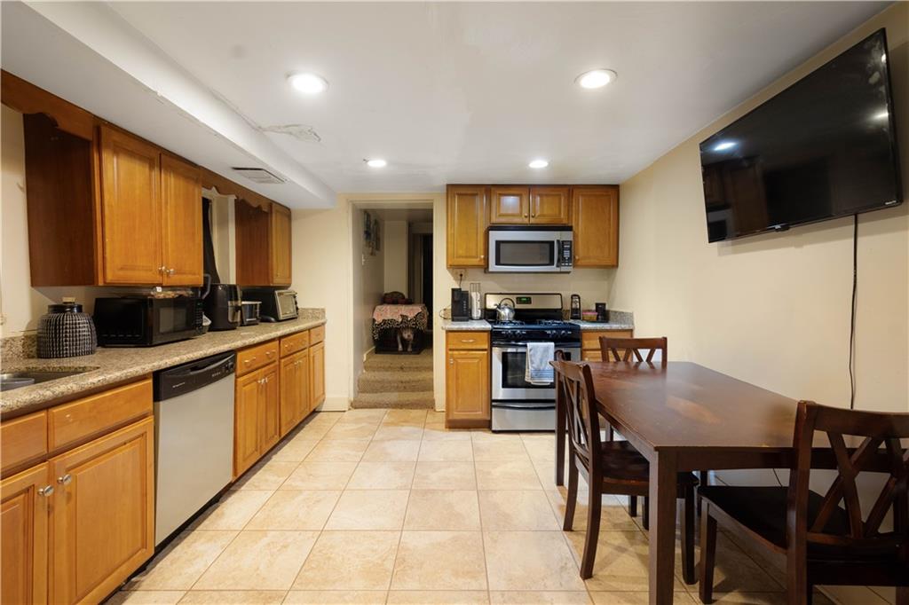 108 Pius Street Pittsburgh, PA 15203 - Photo 6 of 36 a large kitchen with kitchen island granite countertop a stove a sink a dining table and chairs