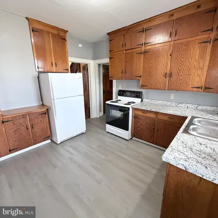 a kitchen with wooden cabinets and white appliances