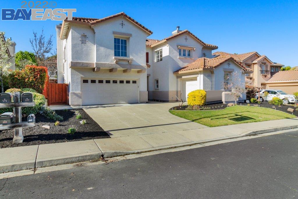 a front view of a house with a garden and parking