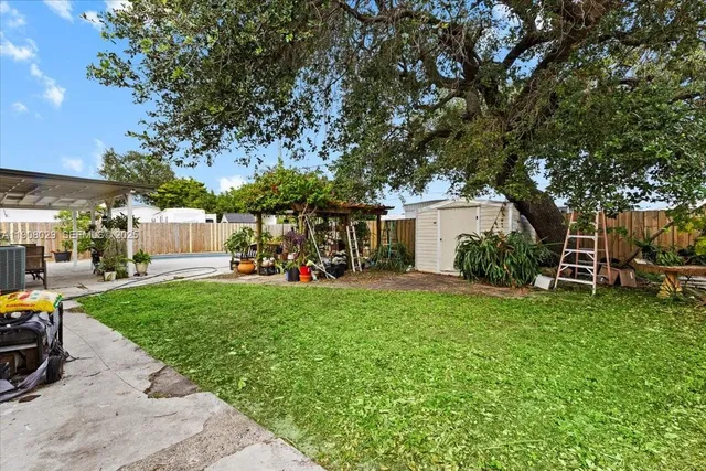 a view of a house with backyard and a tree