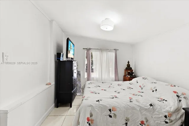 a bedroom with a bed and a refrigerator