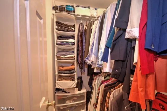 a view of walk in closet with clothes and shoes