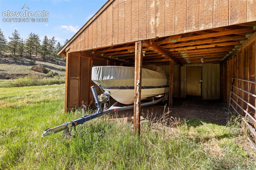 658 Conestoga Creek Road Florissant, CO 80816 - Photo 38 of 50 Carport, stalls, storage off rear of barn.