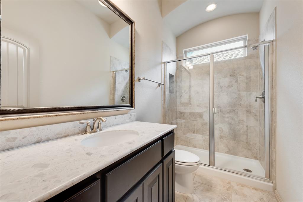 9641 Calaveras Road Fort Worth, TX 76177 - Photo 15 of 24 a bathroom with a granite countertop sink a toilet a mirror and shower