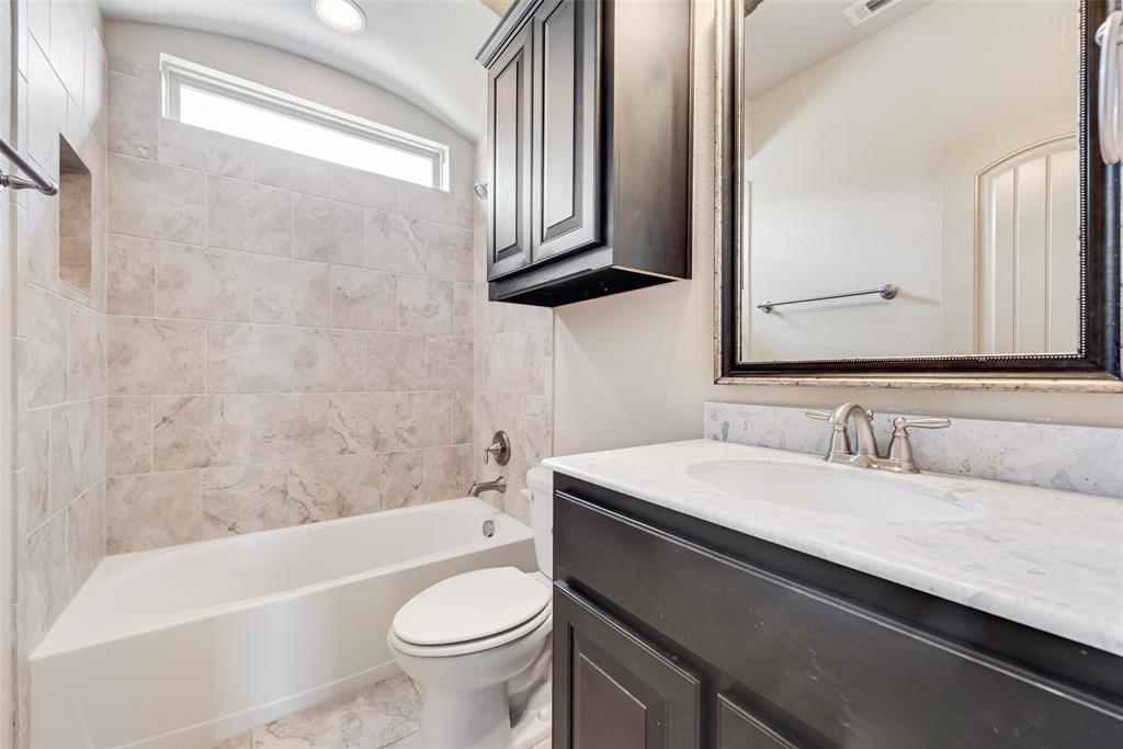 9641 Calaveras Road Fort Worth, TX 76177 - Photo 21 of 24 a bathroom with a sink a toilet a mirror and bathtub