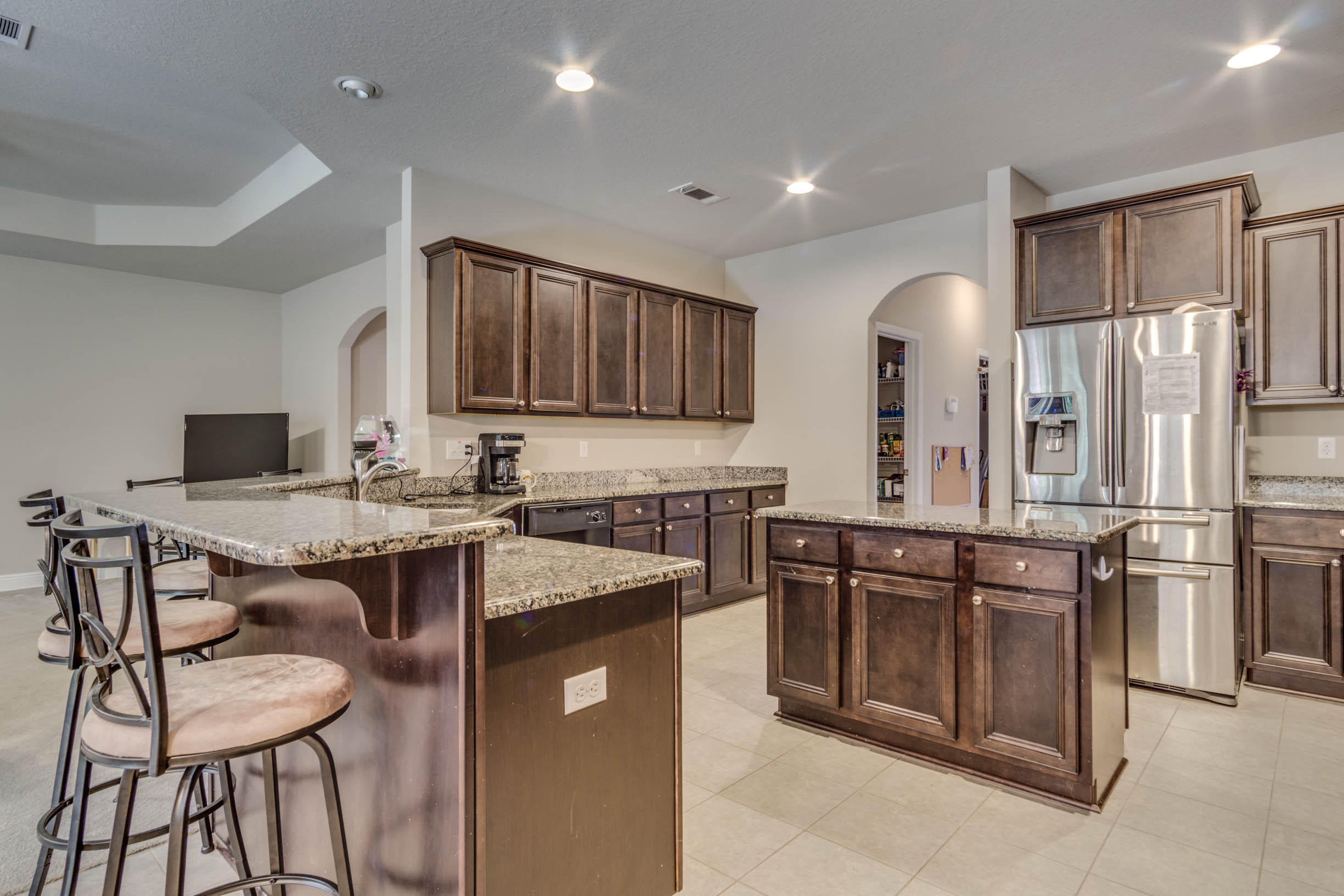 644 Red Fern Road Crestview, FL 32536 - Photo 21 of 46 a kitchen with stainless steel appliances granite countertop a stove top oven a sink refrigerator and chairs