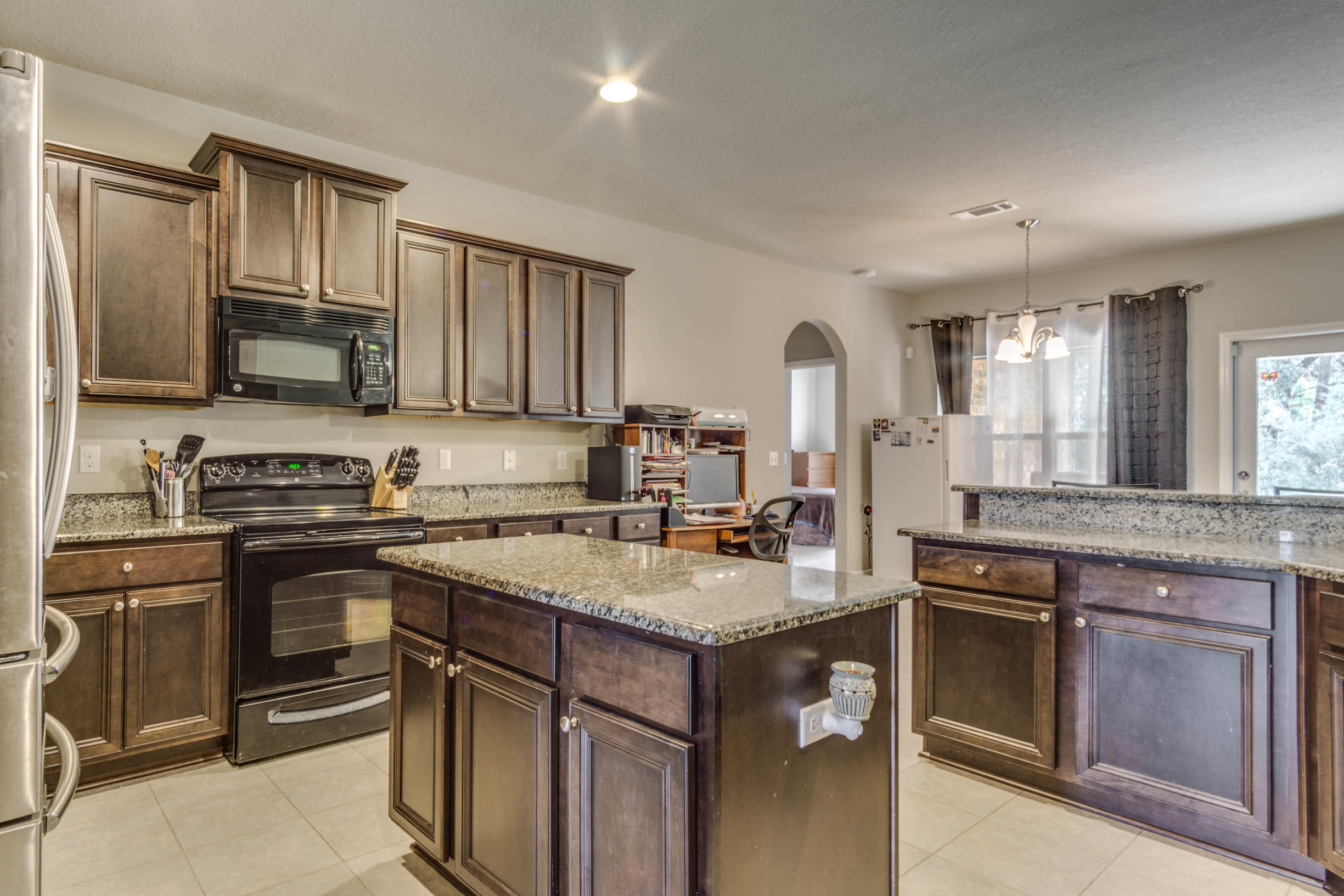 644 Red Fern Road Crestview, FL 32536 - Photo 23 of 46 a kitchen with a stove a sink and a microwave