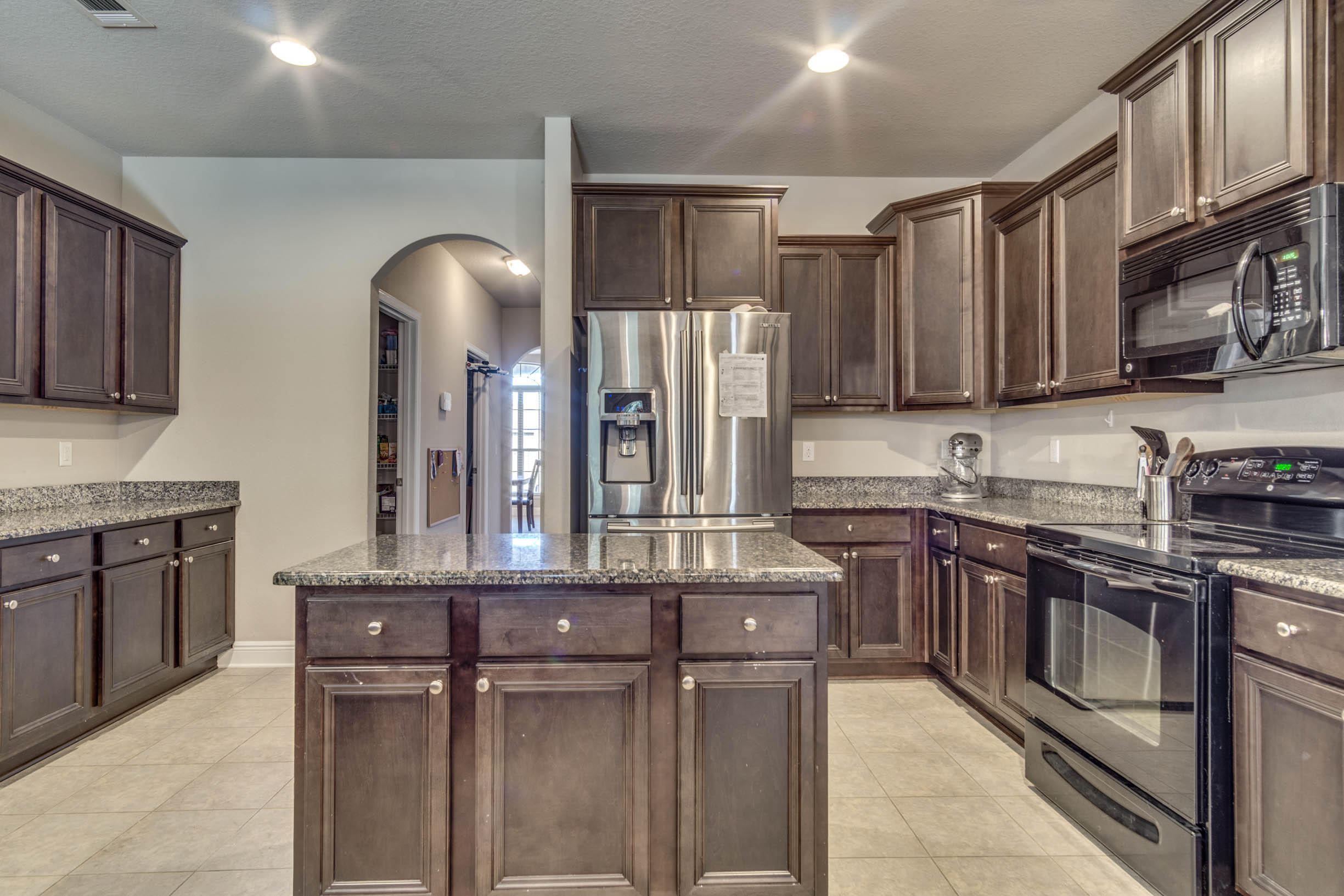 644 Red Fern Road Crestview, FL 32536 - Photo 26 of 46 a kitchen with stainless steel appliances granite countertop a stove top oven a sink dishwasher and a refrigerator with wooden cabinets