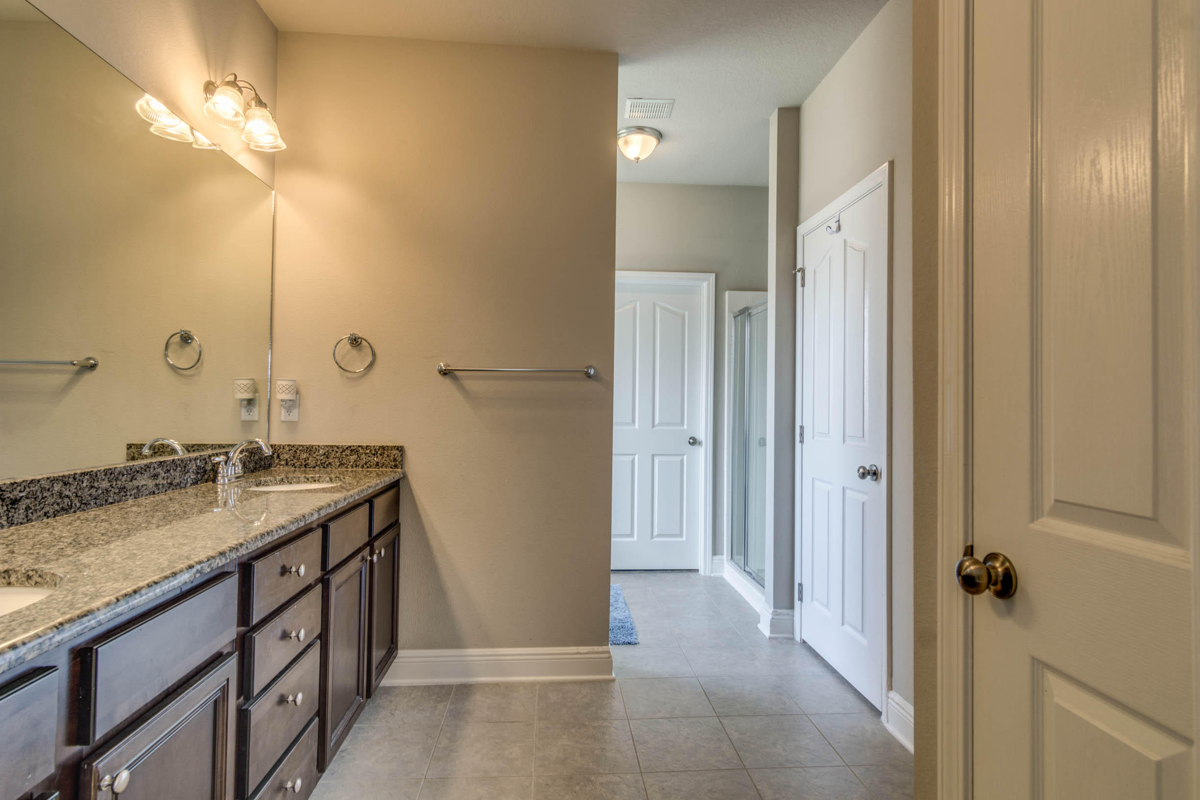 644 Red Fern Road Crestview, FL 32536 - Photo 40 of 46 a bathroom with a granite countertop sink a mirror and a shower