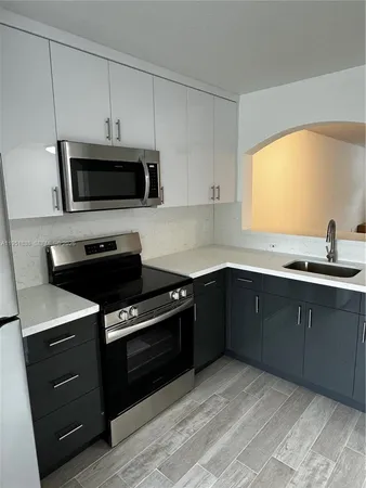 a kitchen with a sink and steel appliances