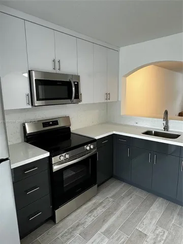 a kitchen with a sink and steel appliances