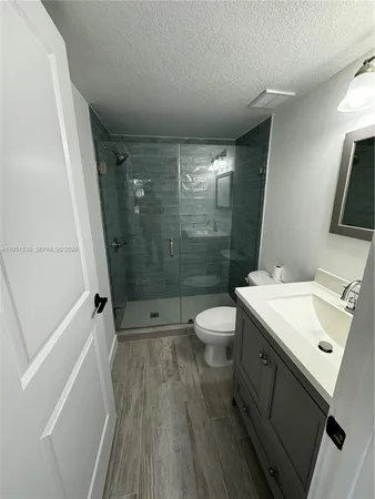 a bathroom with a sink a toilet a mirror and shower
