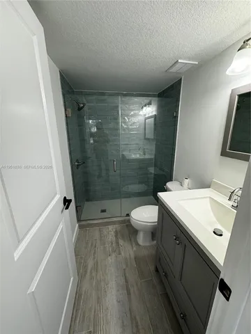 a bathroom with a sink a toilet a mirror and shower