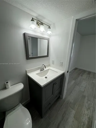 a bathroom with a toilet sink and mirror