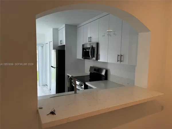 a kitchen with a refrigerator and a stove top oven