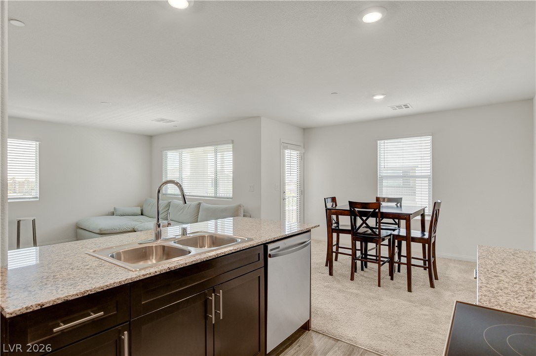 6924 Spicy Merlot Street North Las Vegas, NV 89086 - Photo 19 of 83 Granite counters and stainless steel appliances outfit this open-concept kitchen with dining area.