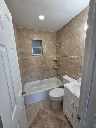 a bath room with a toilet and a tub